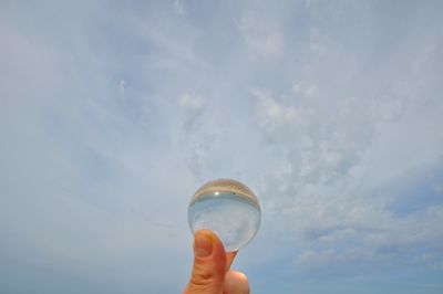 Close-up of crystal ball against sky