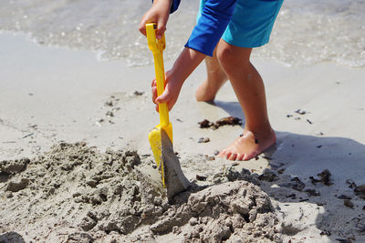 Low section of man standing at beach