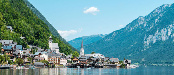 Scenic view of lake and houses against sky