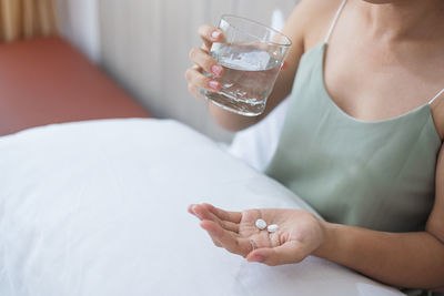 Midsection of woman eating medicines