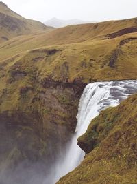 Scenic view of waterfall against sky