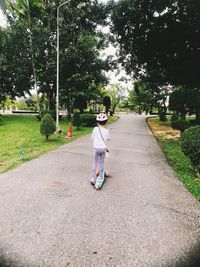 Rear view of woman on bicycle against trees