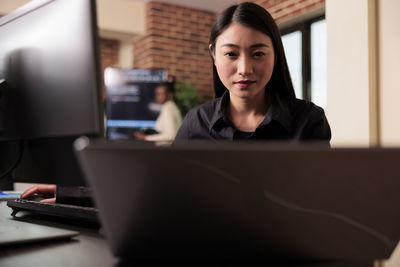 Portrait of woman using laptop on table