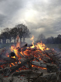 Bonfire on wooden structure against sky