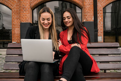 Portrait of a smiling young woman using phone