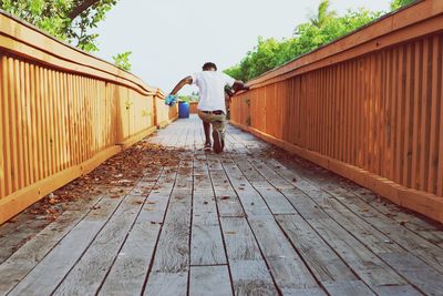 Rear view of man standing on footpath