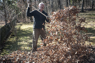 Man standing on field by trees in forest