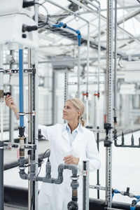 Biologist examining pipes in industry