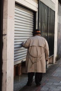 Rear view of man working on footpath