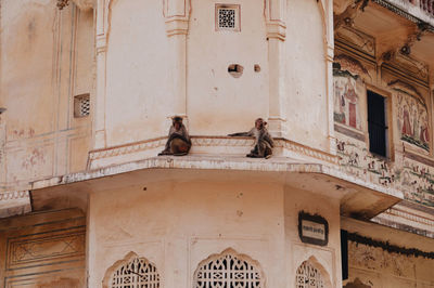 Low angle view of historic building with monkeys 