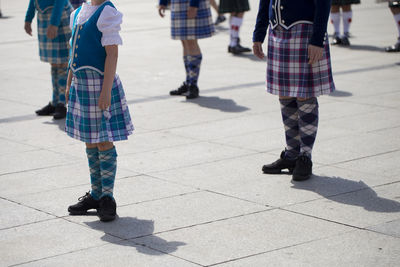 Low section of bagpiper standing on footpath