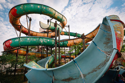 Close-up of old water slide against sky