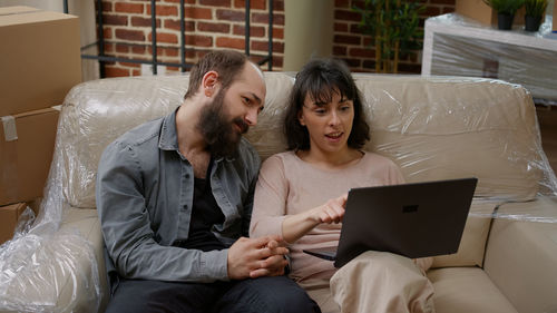 Couples using laptop at home