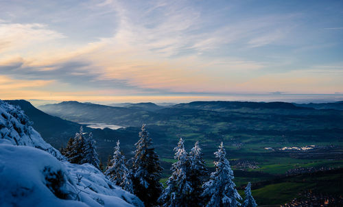 Scenic view of snowcapped mountains against sky during sunset