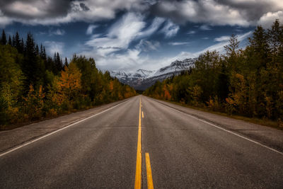 Road amidst trees against sky