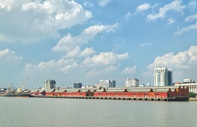 Scenic view of sea by buildings against sky