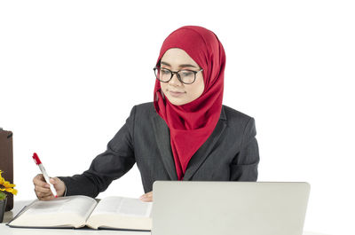 Full length of young woman using smart phone against white background