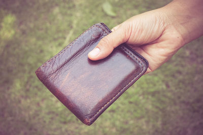 Close-up of person holding wallet outdoors