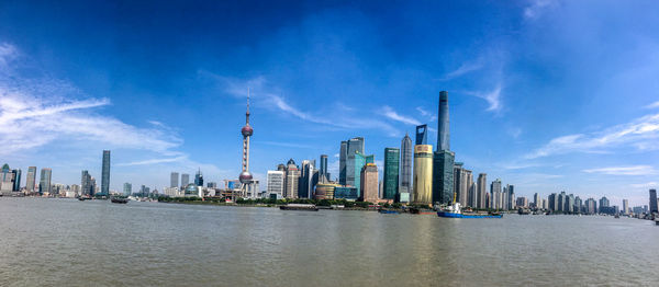 Panoramic view of buildings by river against sky