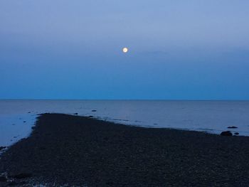 Scenic view of sea against clear sky at night