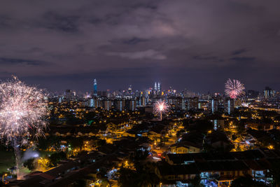 Illuminated cityscape against sky at night