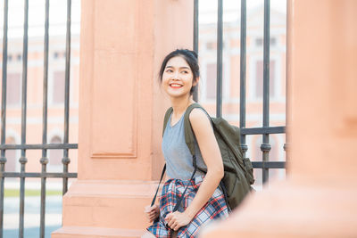 Portrait of smiling young woman sitting outdoors