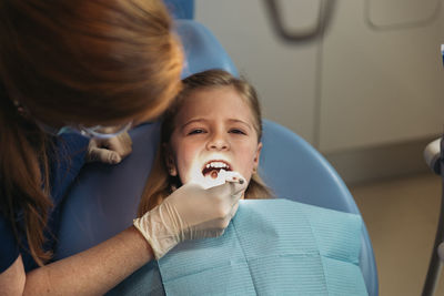 Dentist examining patient mouth in medical clinic