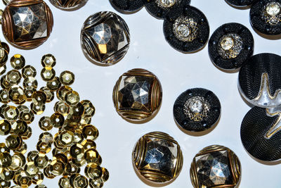 Background texture of the golden round sequins and glossy dark buttons