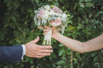 Midsection of woman holding flowering plant