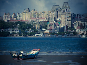 Boats in sea against buildings in city