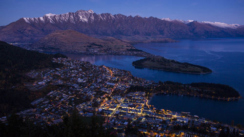 High angle view of lake by mountains against sky