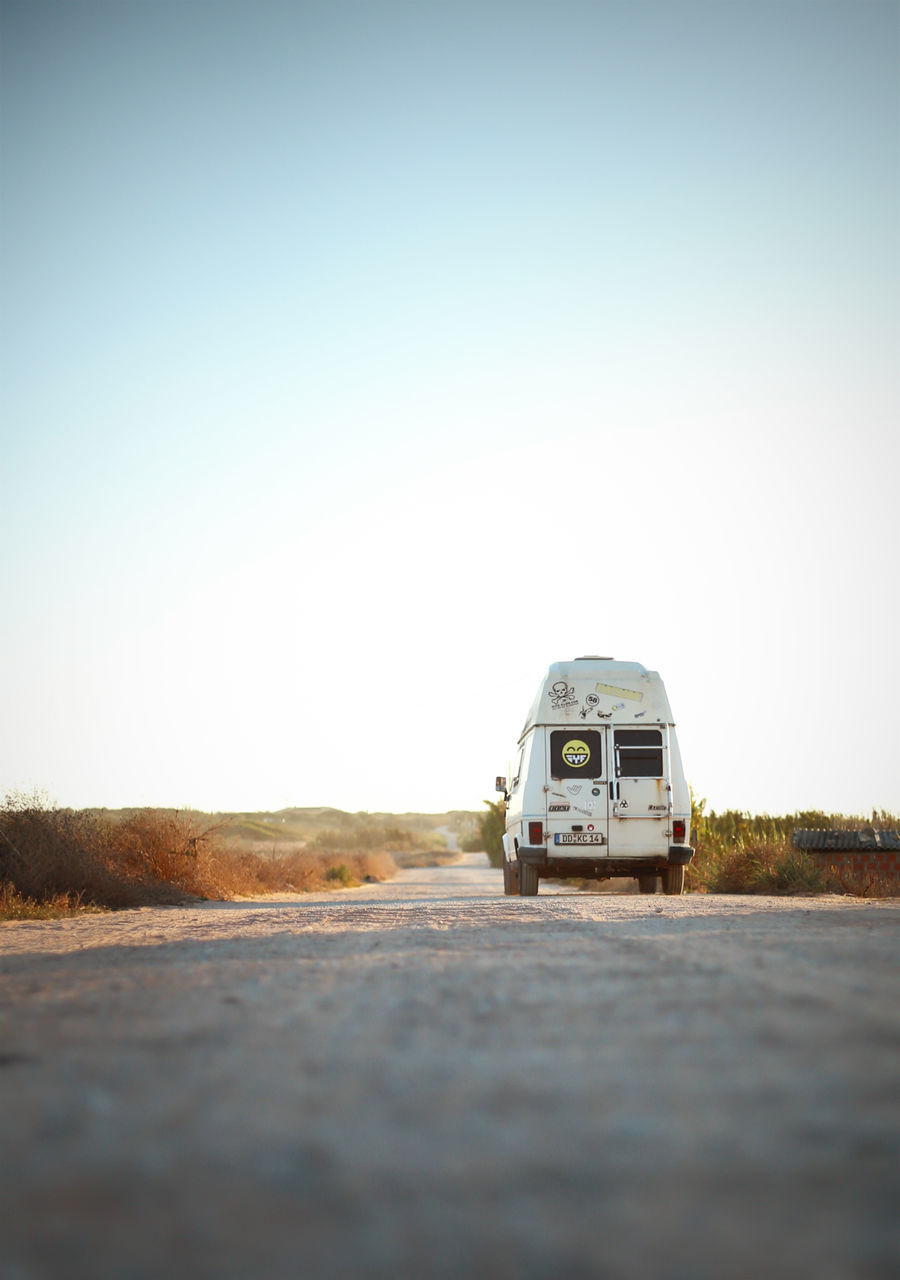 transportation, mode of transportation, land vehicle, sky, clear sky, road, day, motor vehicle, nature, car, no people, selective focus, copy space, the way forward, outdoors, direction, surface level, travel, land, city, arid climate, road trip