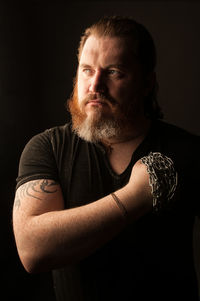 Portrait of young man against black background