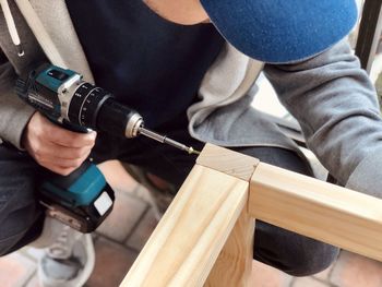 Midsection of man working on wood