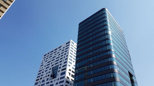 Low angle view of modern building against clear blue sky