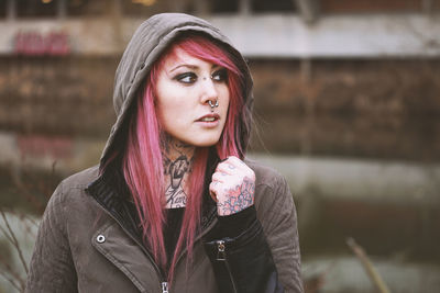 Thoughtful portrait of young woman with piercings and tattoos