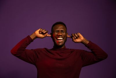 Portrait of smiling young man against gray background