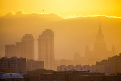 View of skyscrapers in city at sunset