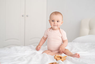 Portrait of cute baby girl lying on bed at home