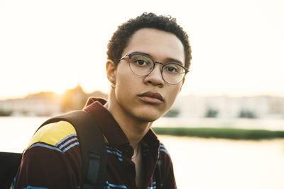 Portrait of male standing at harbor in city during sunset