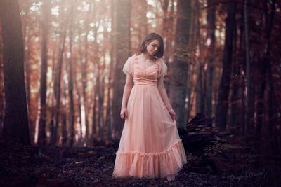 Portrait of young woman standing in forest