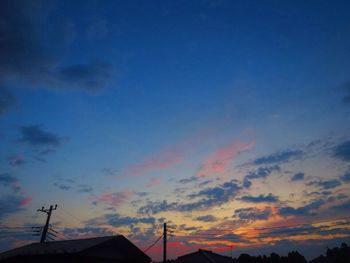 Low angle view of silhouette communications tower against sky during sunset