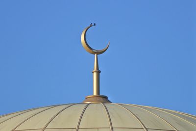 Low angle view of cross against clear blue sky