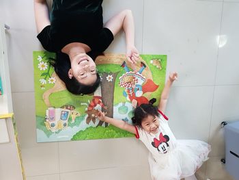 High angle view of siblings sitting on floor