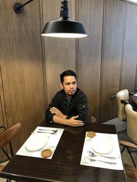 Portrait of young man sitting on table