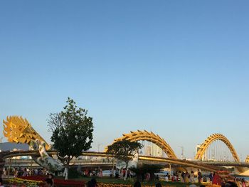 People in amusement park against clear blue sky