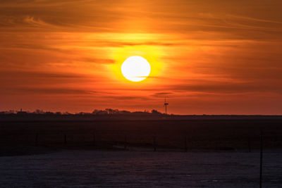 Scenic view of field against orange sky