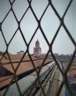 Tower seen through chainlink fence against sky