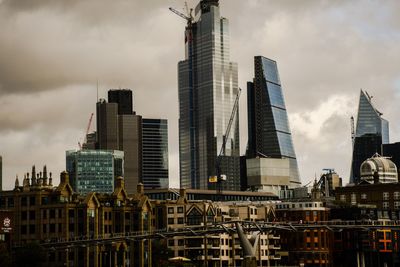 Buildings in city against cloudy sky