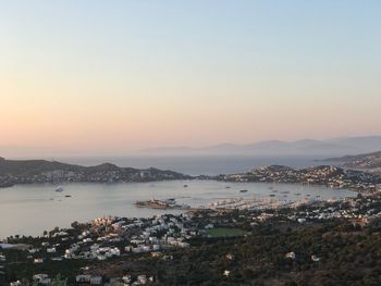 Scenic view of sea and cityscape against sky during sunset